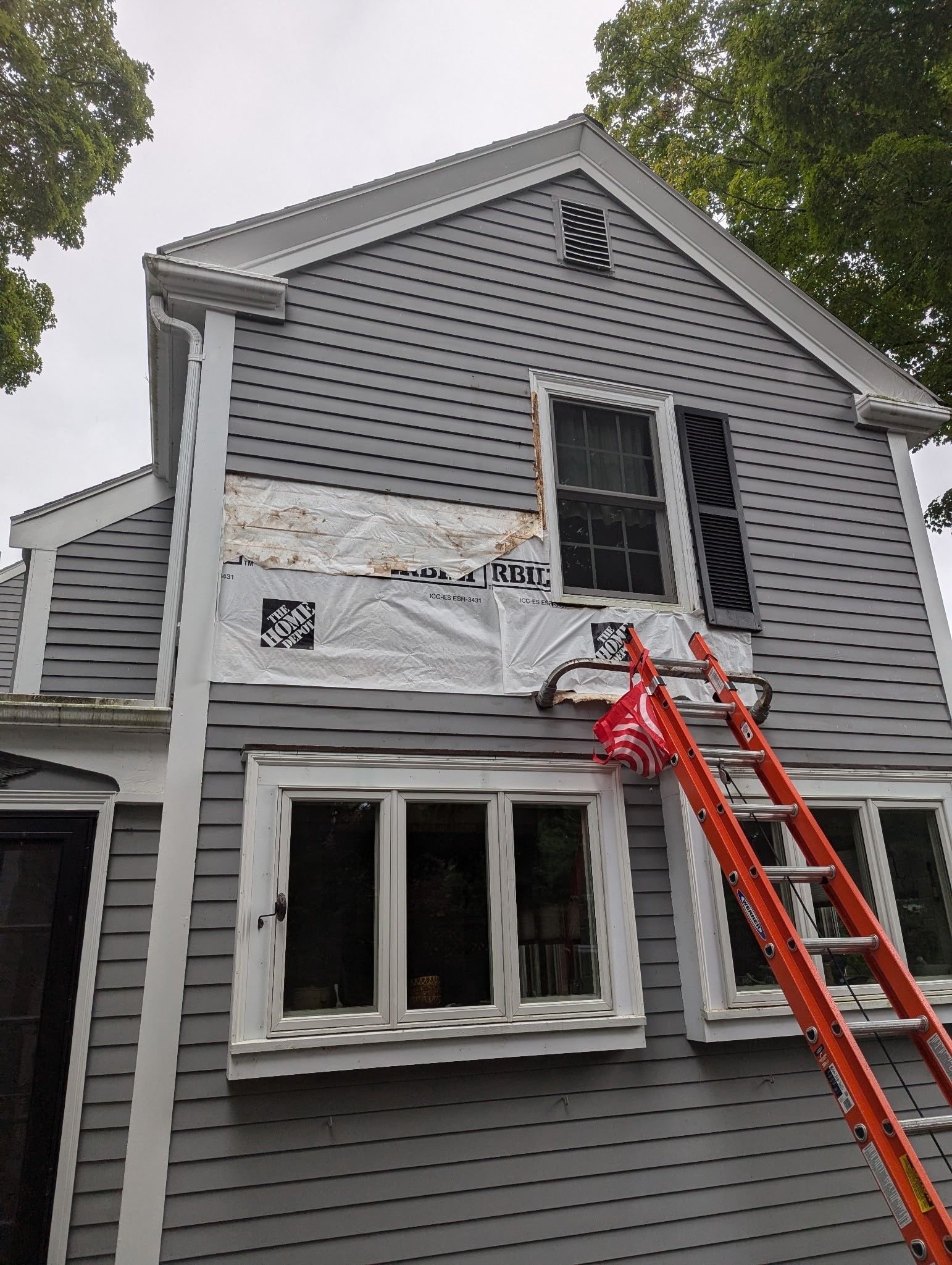 A ladder is sitting on the side of a house.