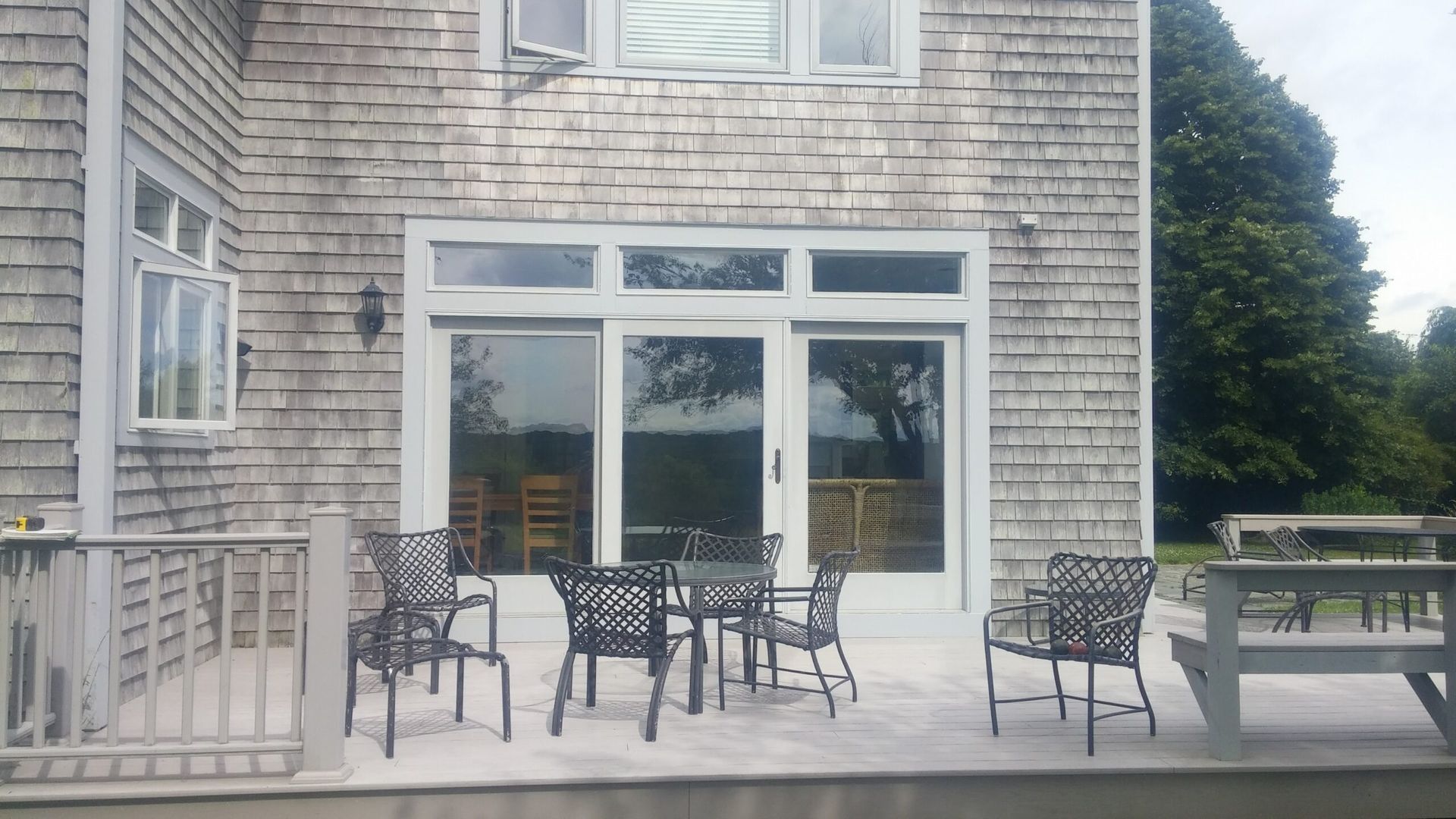 A patio with a table and chairs in front of a brick house.