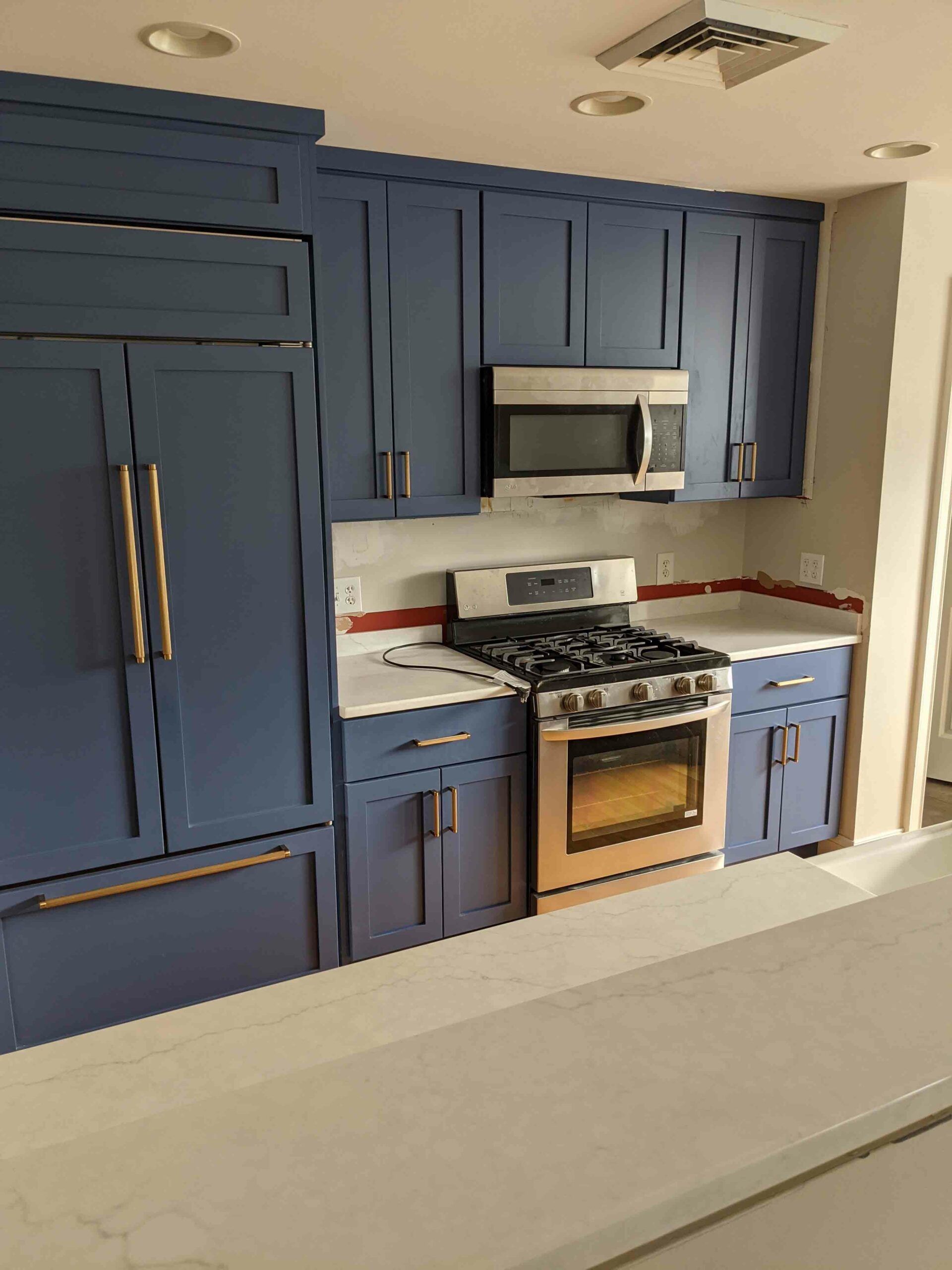 A kitchen with blue cabinets and stainless steel appliances
