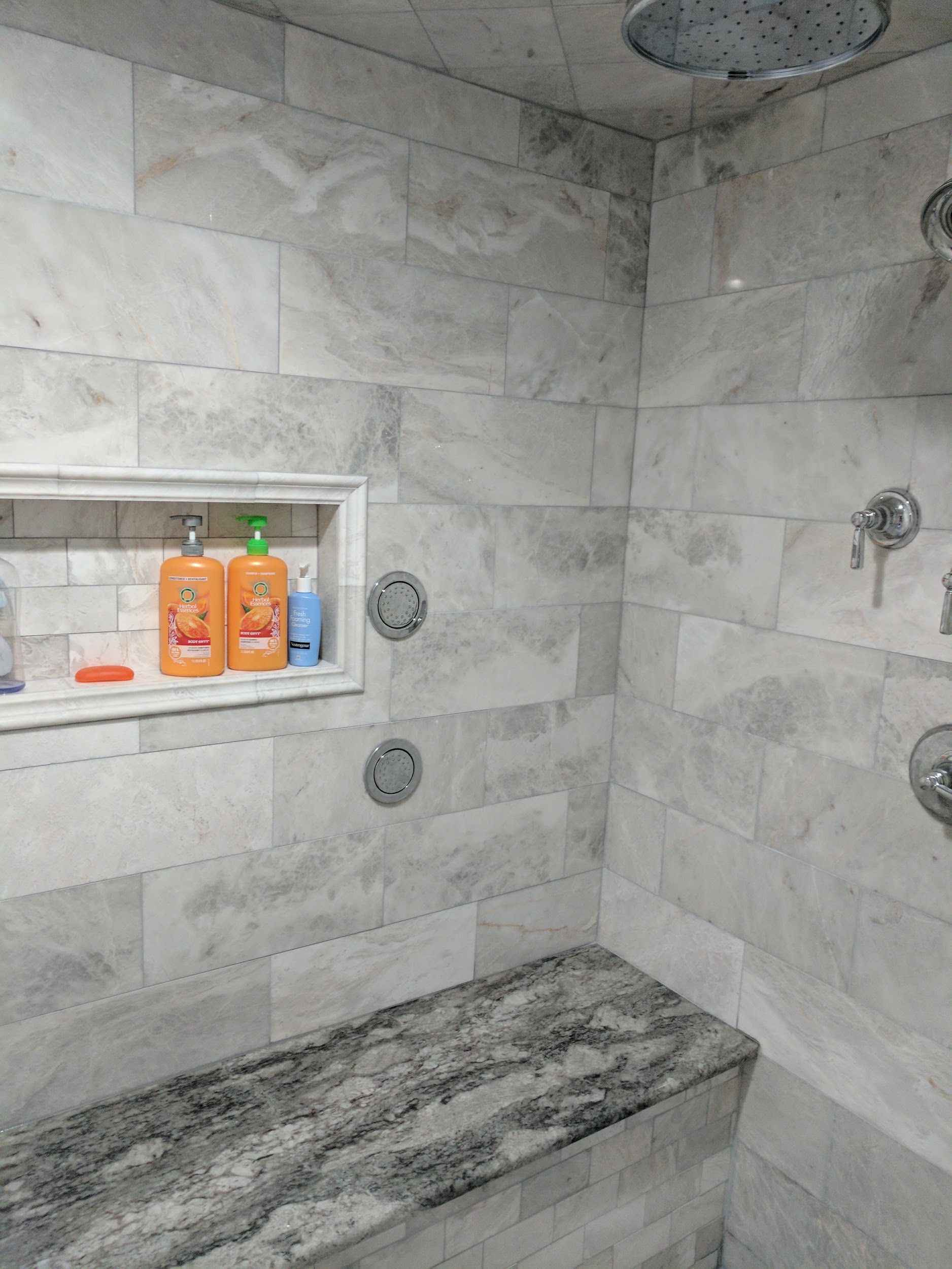A bathroom with a shower and a bench.