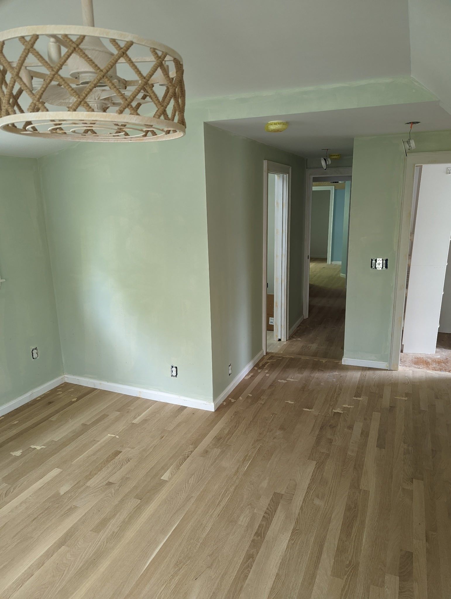 A living room with hardwood floors and a chandelier hanging from the ceiling.