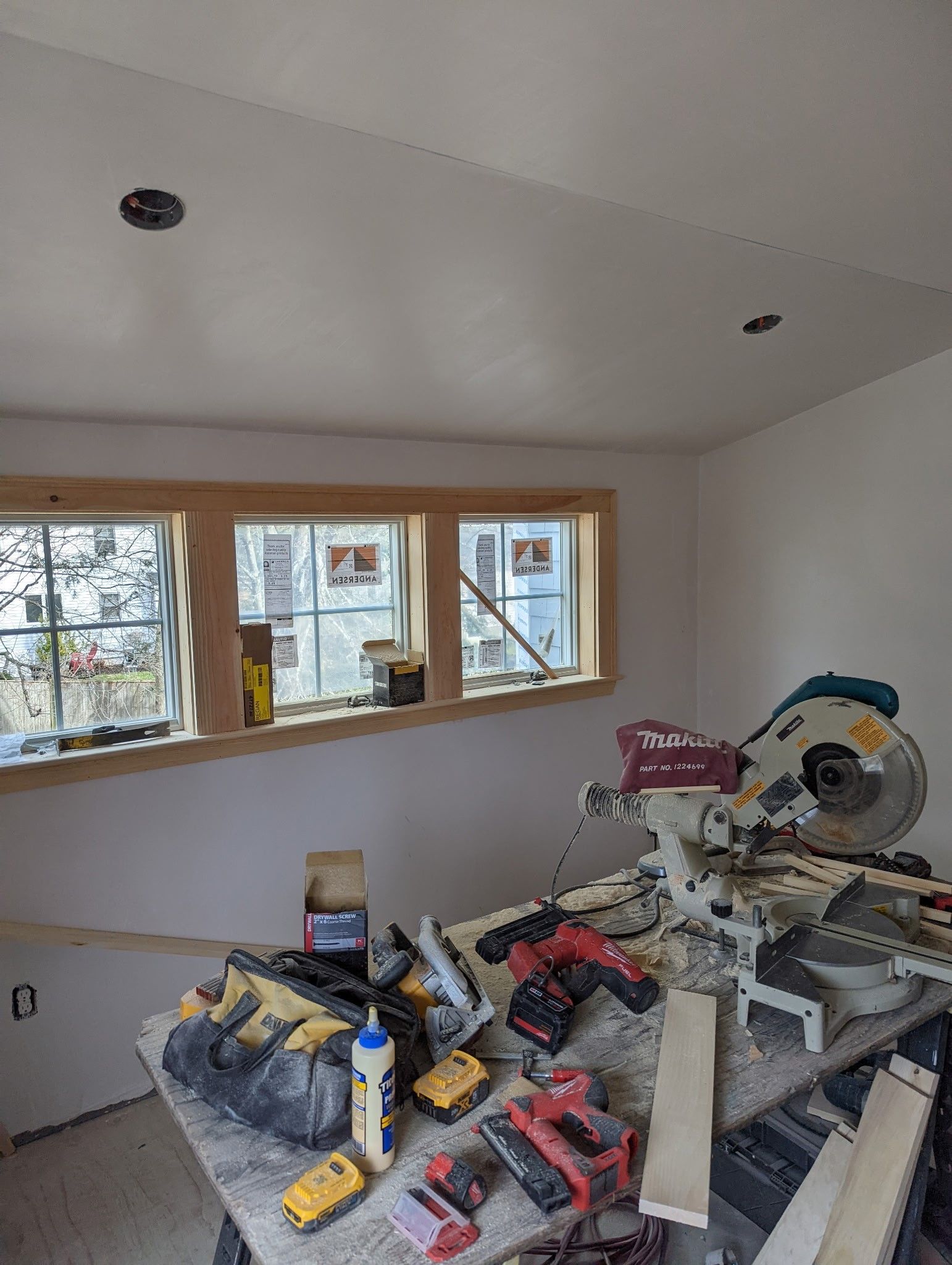 A room with a lot of tools on a table and a window.
