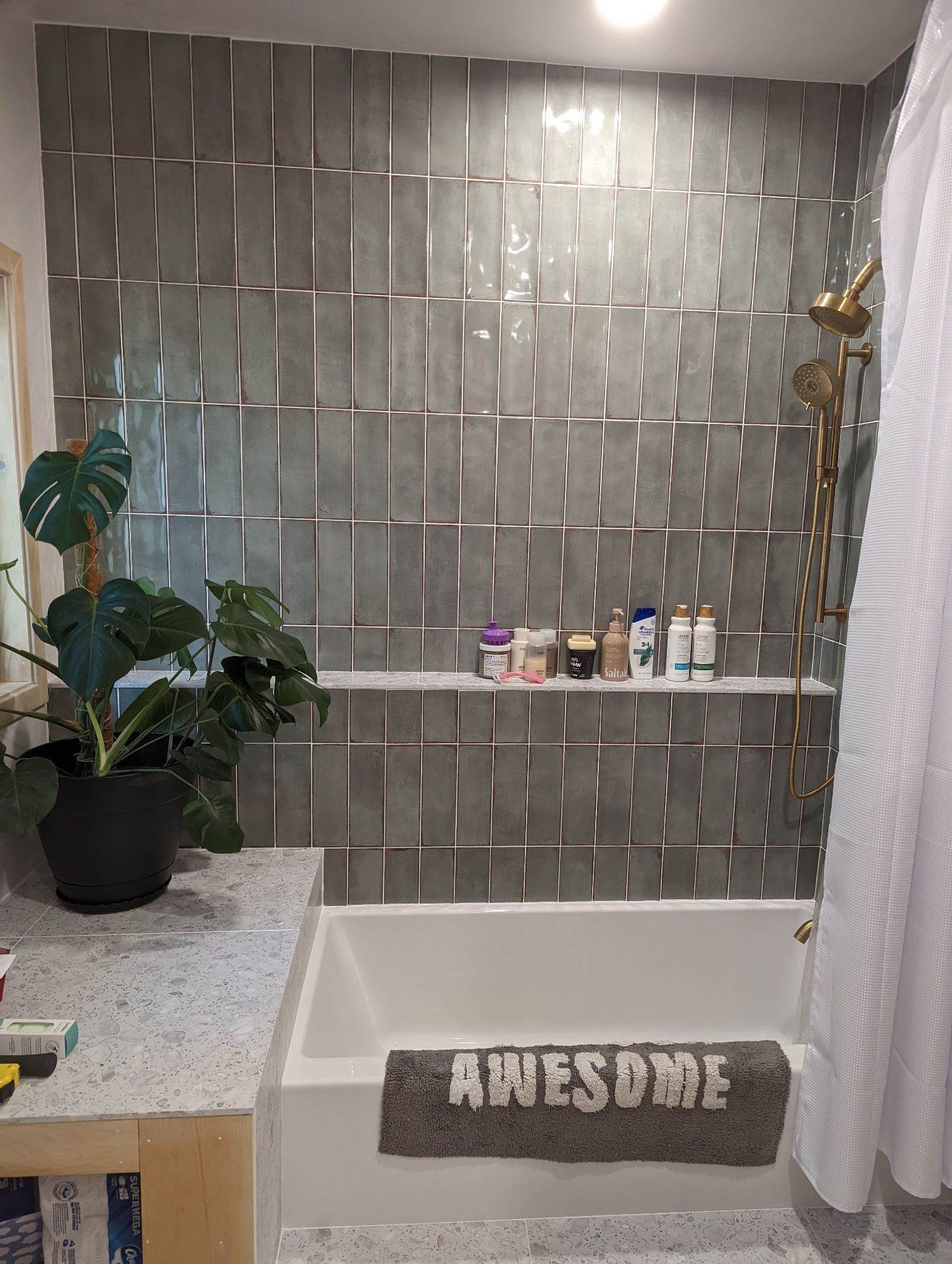 A bathroom with a tub , shower , and a rug that says awesome.