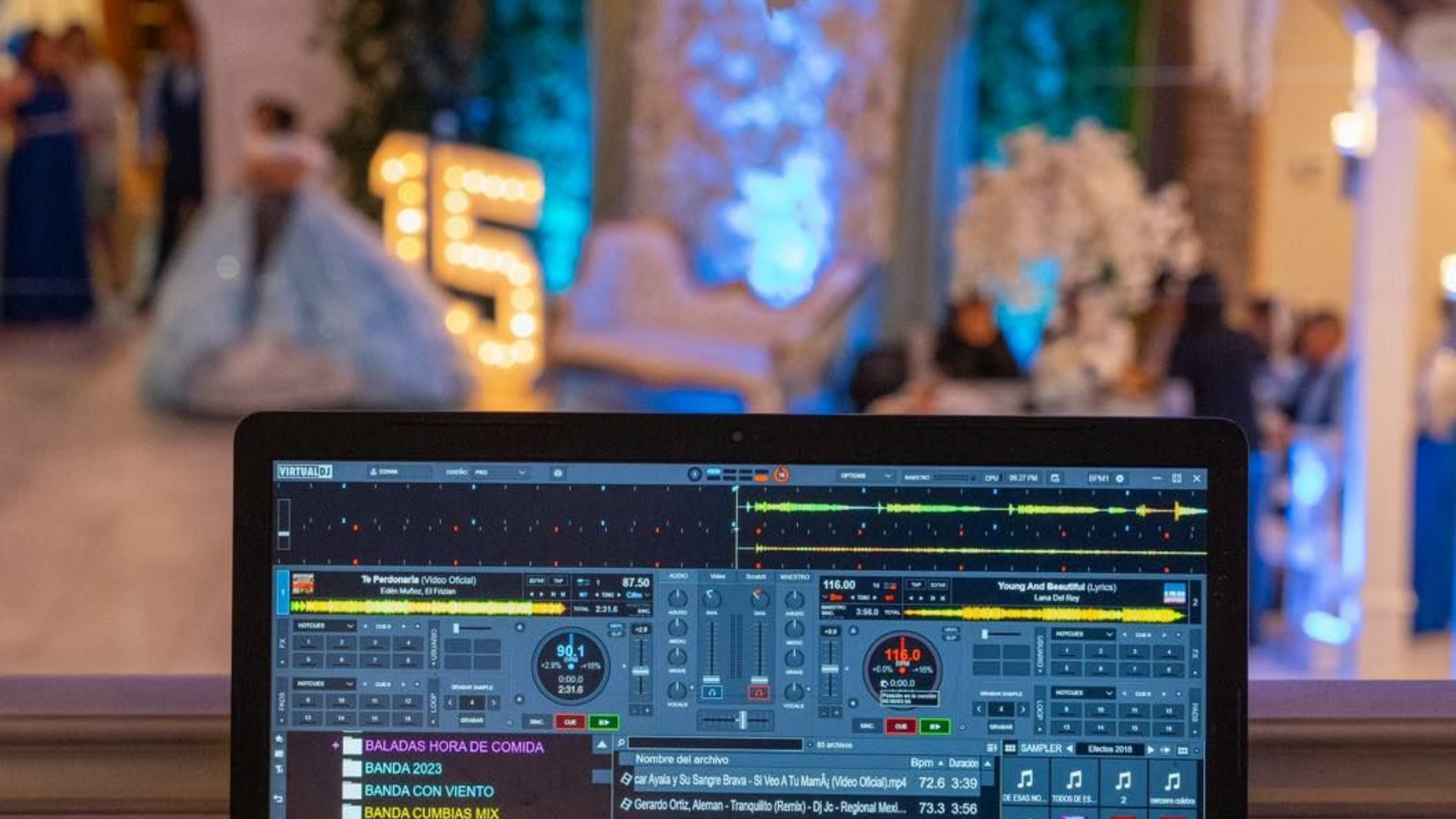 Elegant all-white wedding reception. Round tables with floral centerpieces, set in a bright, spacious room with chandeliers.