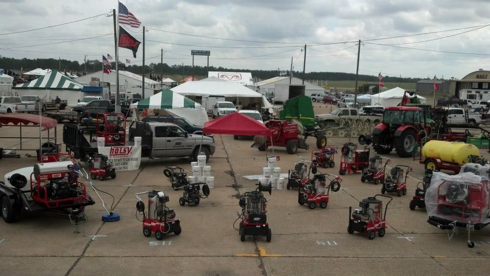 A lot of snow blowers are lined up in a parking lot