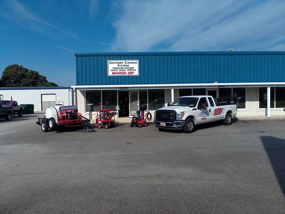 Two trucks are parked in front of a blue building