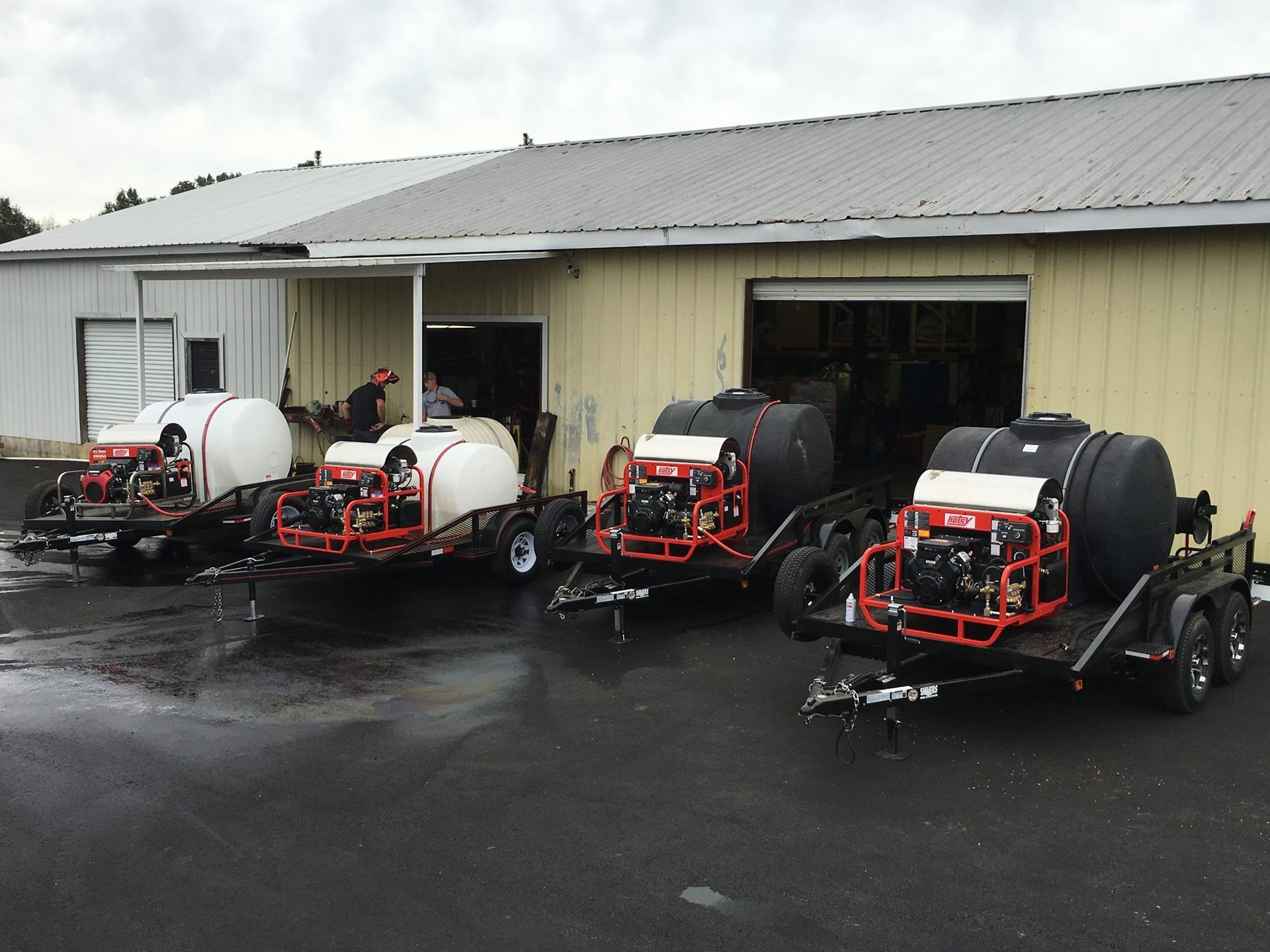 A row of trailers are parked in front of a building.