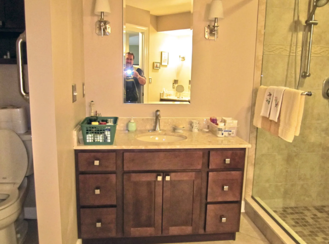 Bathroom with vanity, sink, mirror, toilet, and shower.