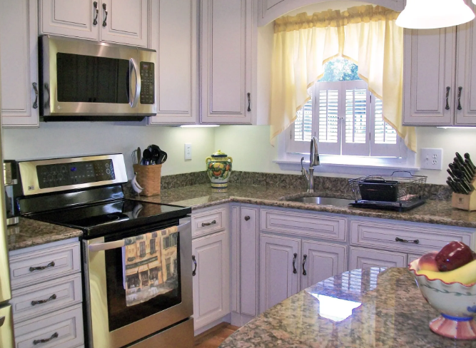 Kitchen with white cabinets, stainless steel appliances, and granite countertops.