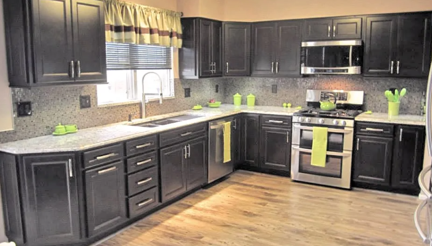 Modern kitchen with dark cabinets, stainless steel appliances, and granite countertops.