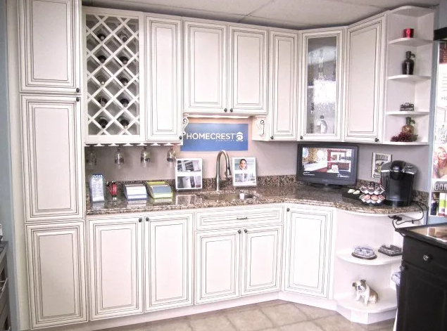 White kitchen cabinets with a countertop, sink, and TV.