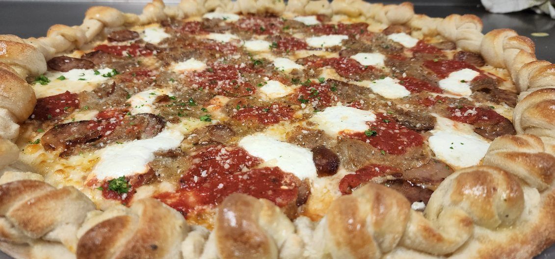 A close up of a pizza with sauce and cheese on a table.