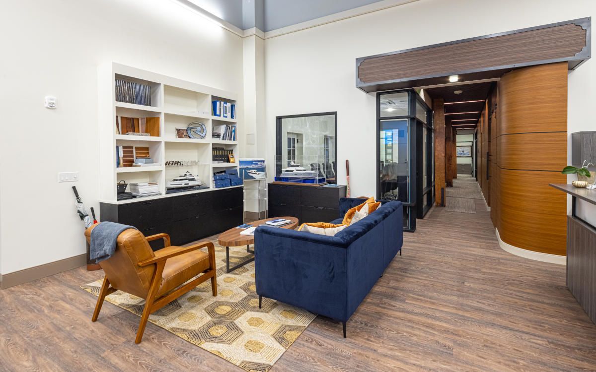 Waiting room with a leather chair, blue couch, coffee table, and hallway entrance.
