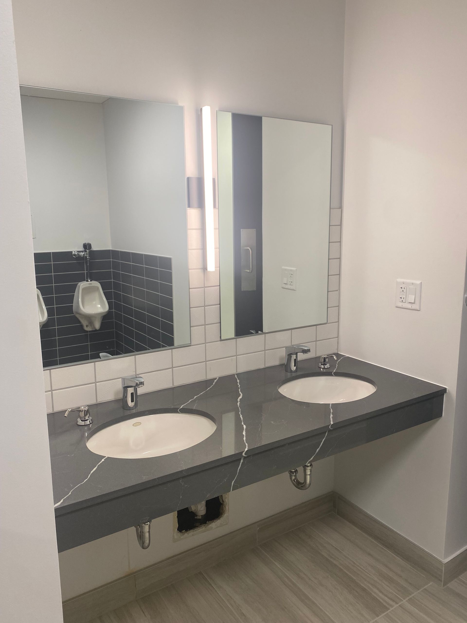 Public restroom with two sinks, a gray countertop, and a large mirror.