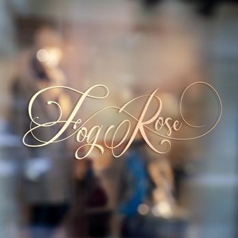 Gold cursive FogRose logo on a frosted glass window