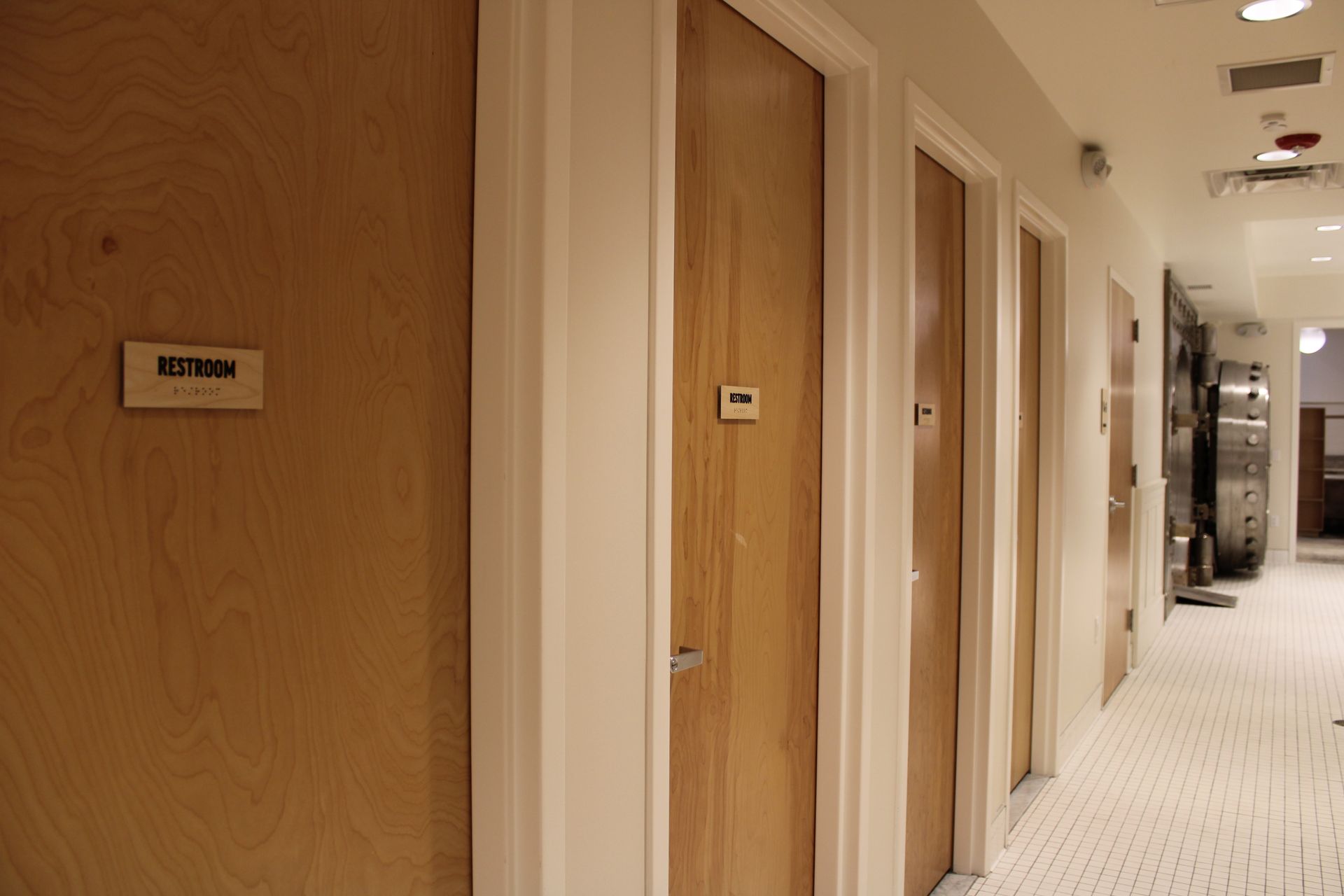 Hallway with light wood doors, white trim, and a patterned carpet.