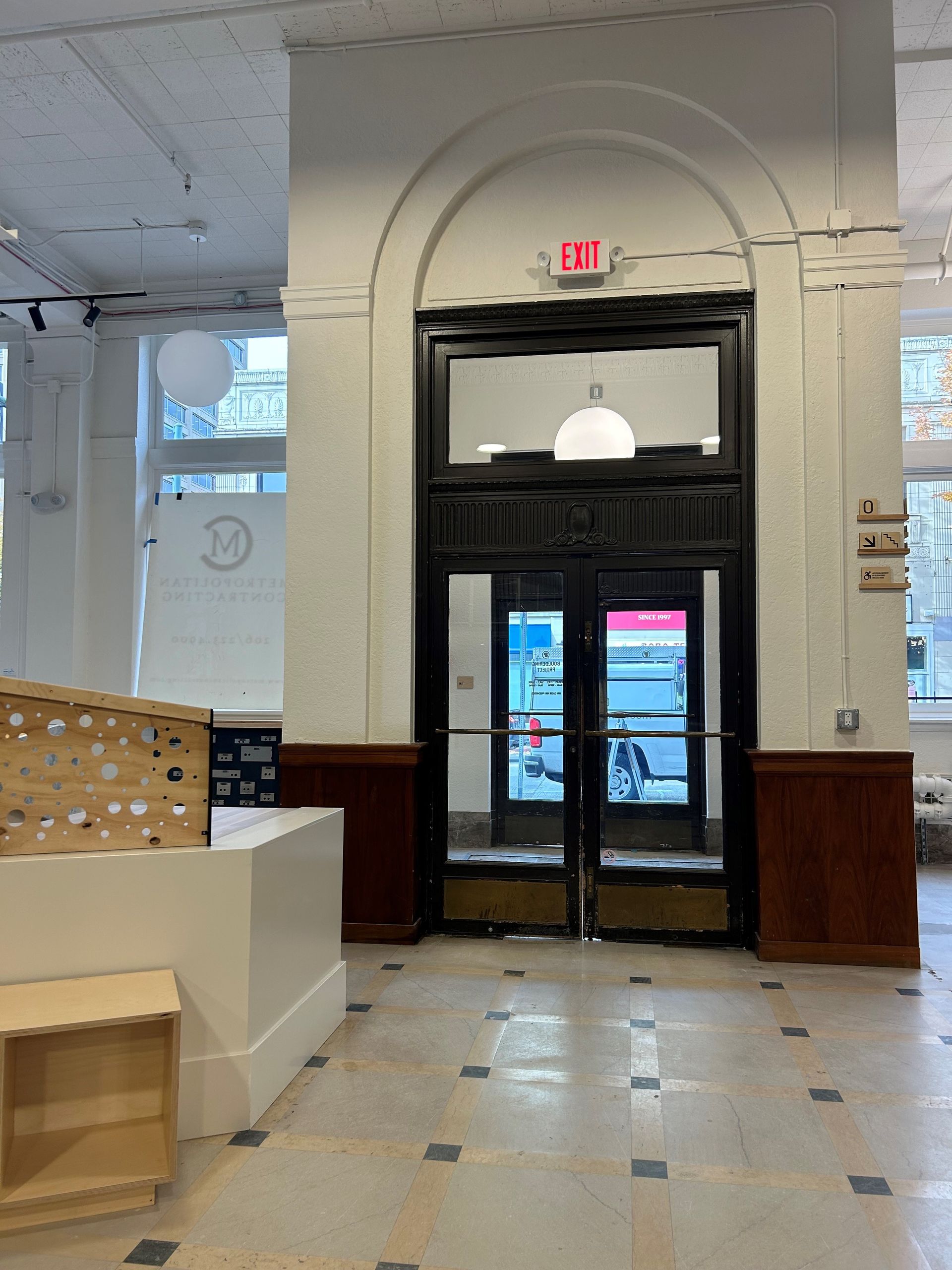 Interior doorway with glass doors under an arched entryway. Exit sign above.