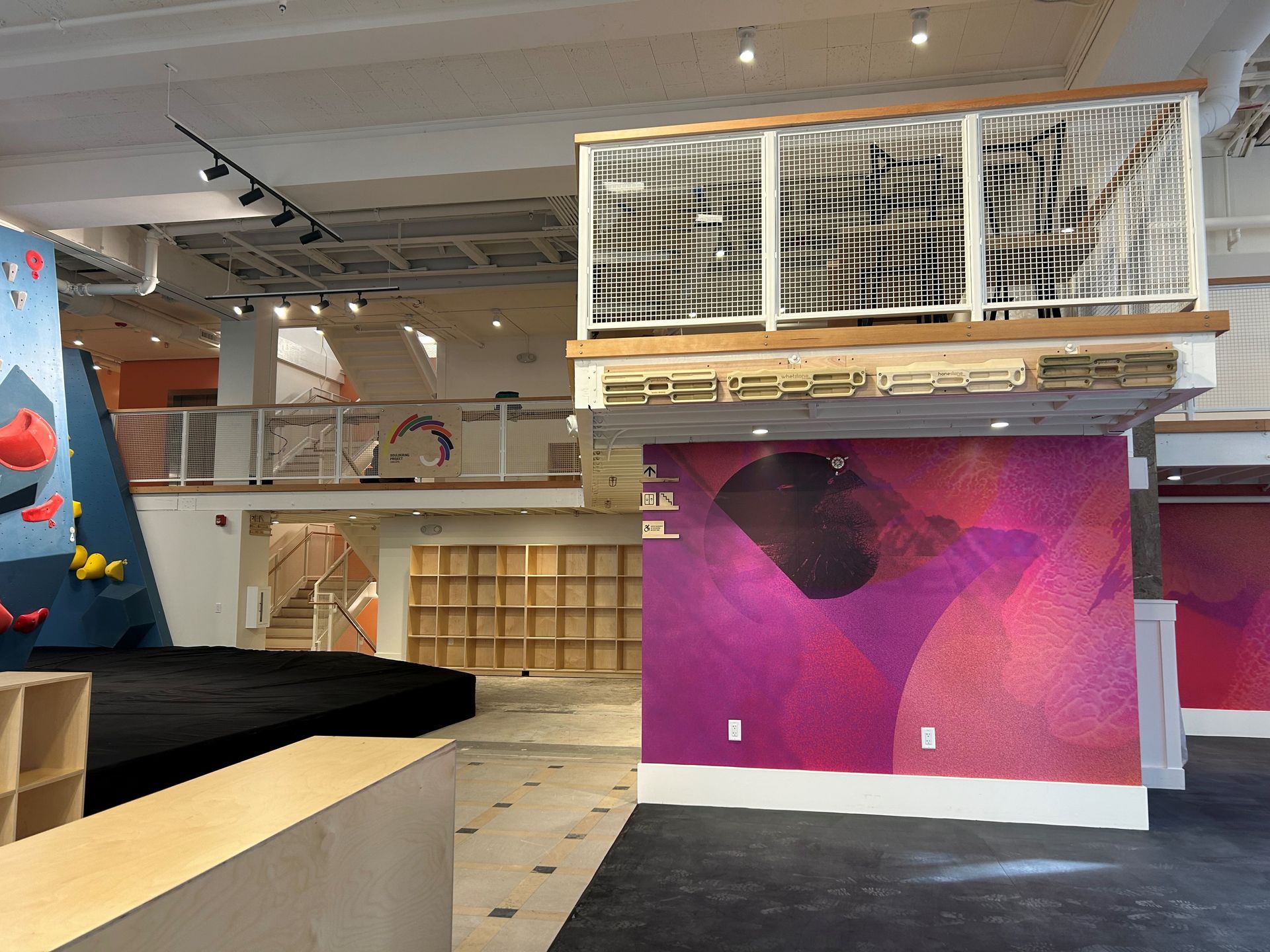 Interior view of an open space with abstract murals and a wooden structure.