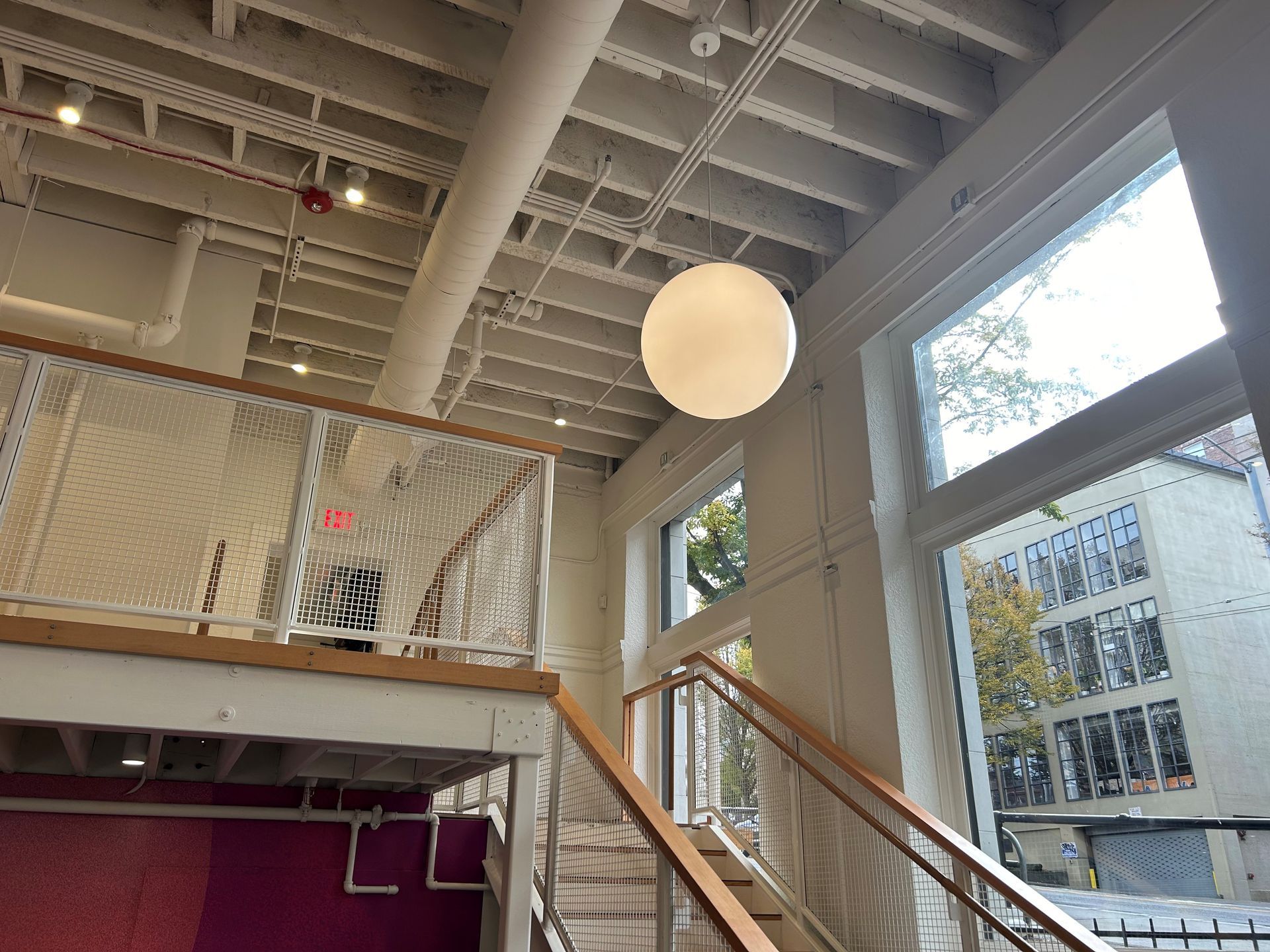 Bright white interior with a large round light and staircase.