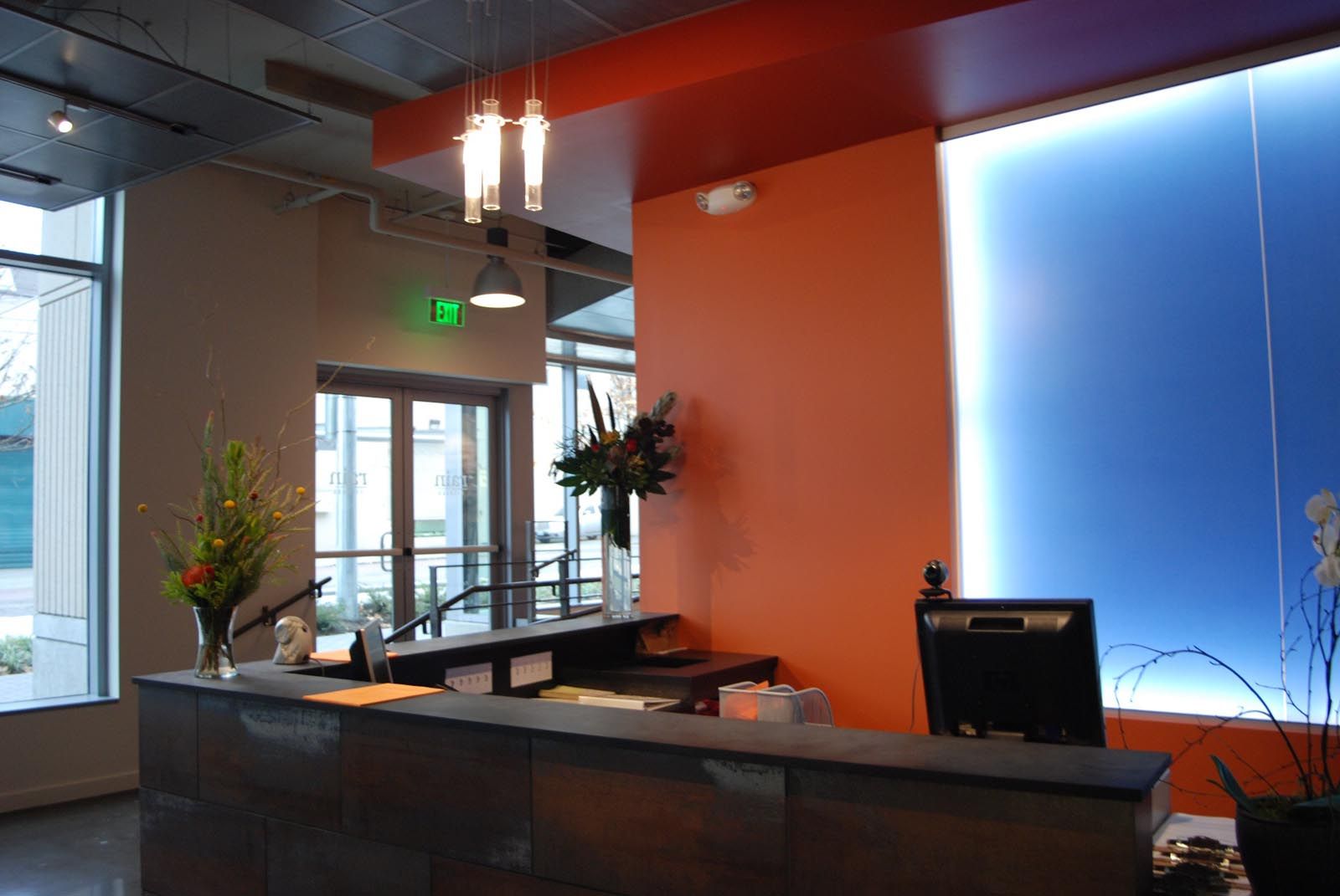 Reception desk in modern office with orange and blue accents.
