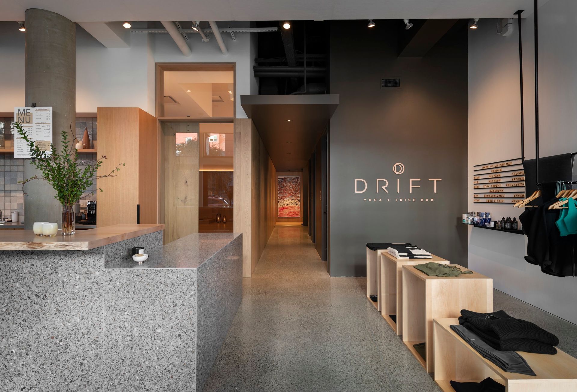 Interior of Drift, a spa and retail space, with terrazzo counter, clothing displays, and a long hallway.