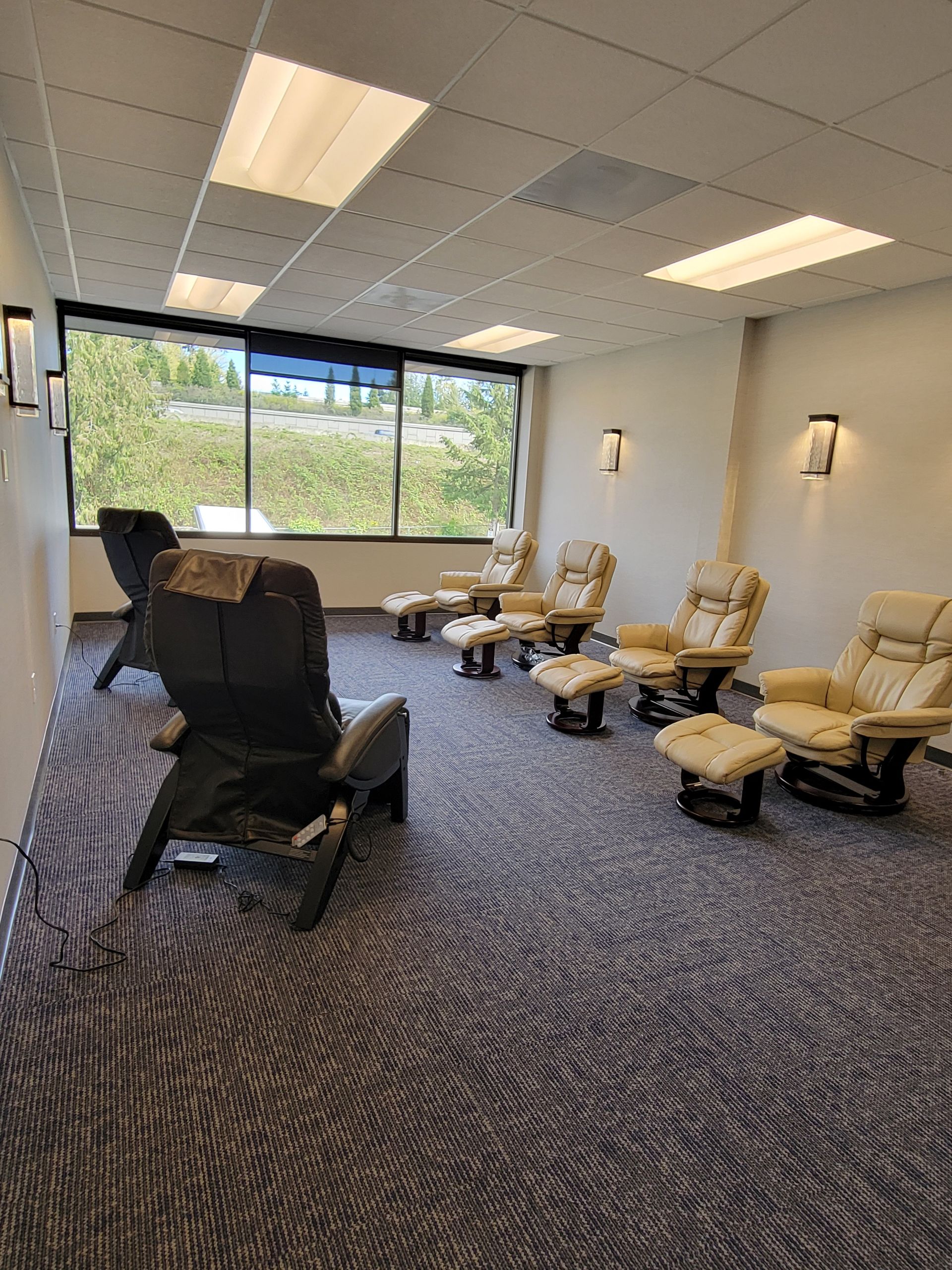 Relaxation room with reclining chairs and footrests. Windows offer a view.