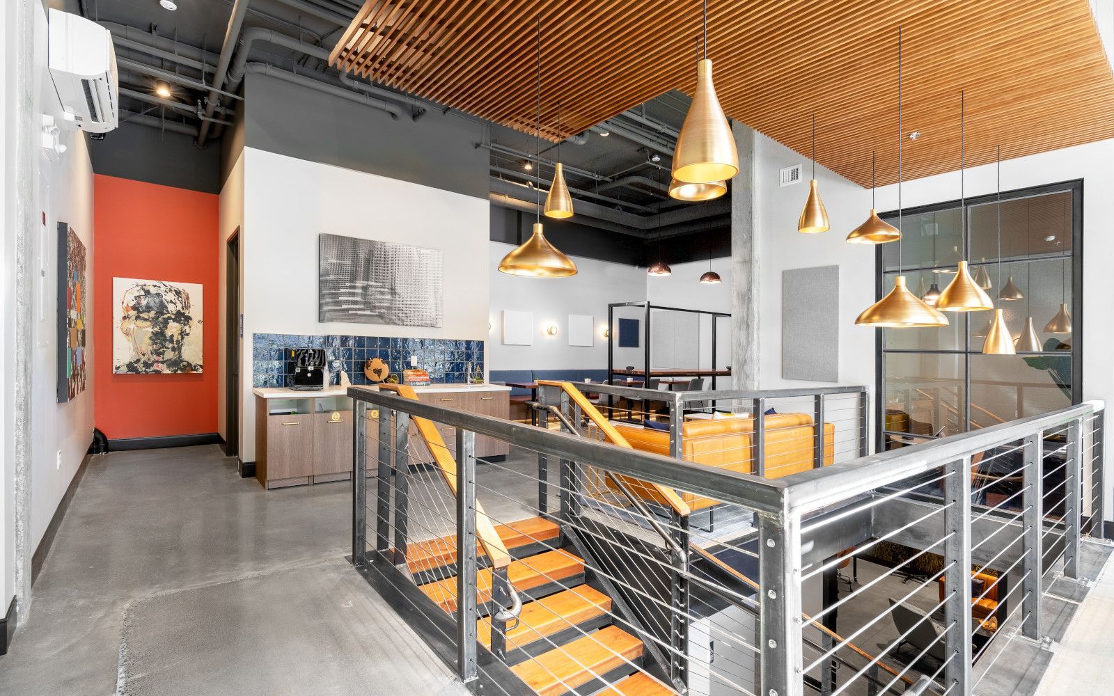 Modern interior with staircase, gold light fixtures, and open seating area.