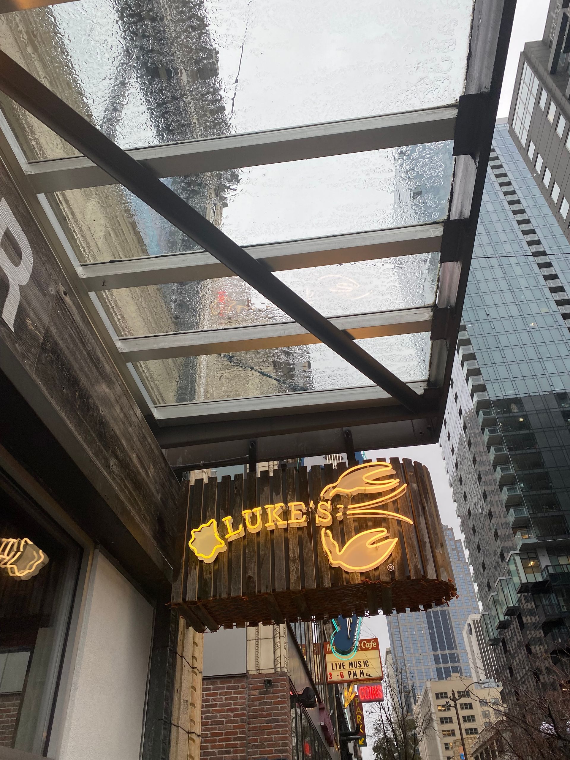 Luke's Lobster restaurant sign under a glass awning on a city street.