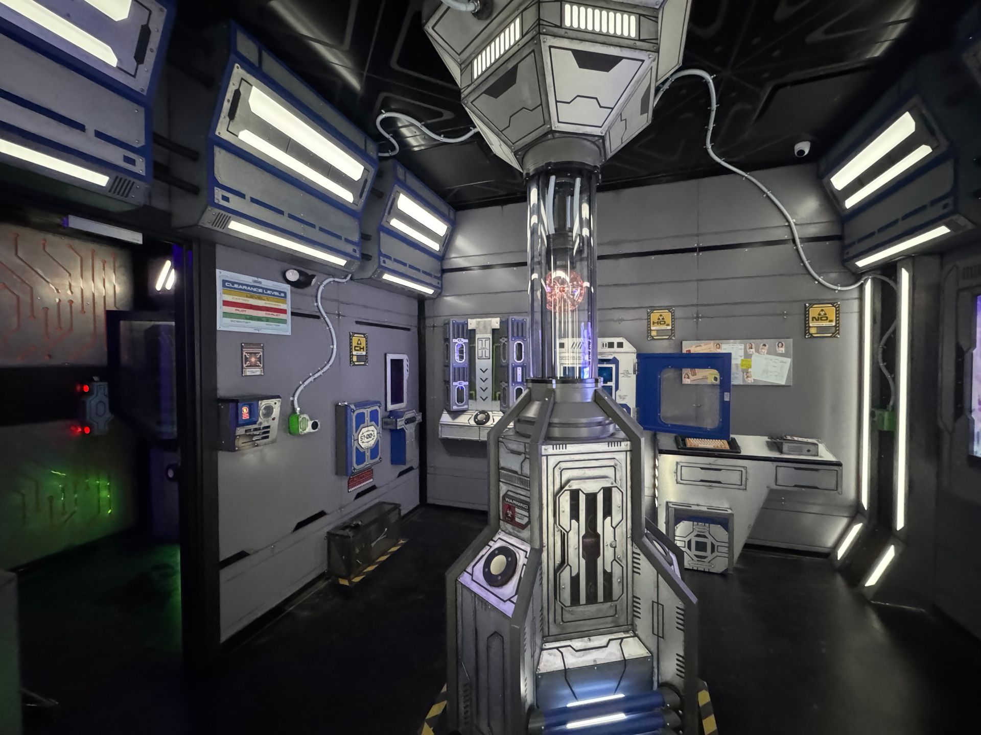 Sci-fi control room with a central glowing core, computer panels, and monitors.