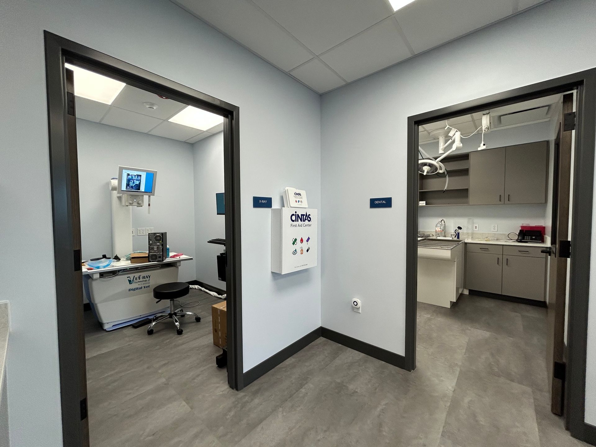 Two doorways leading to examination rooms, in a medical office, grey trim, pale blue walls.