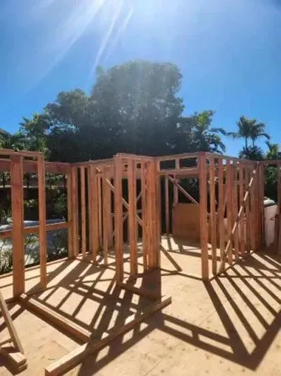 Wooden frame of a building under construction on a sunny day.