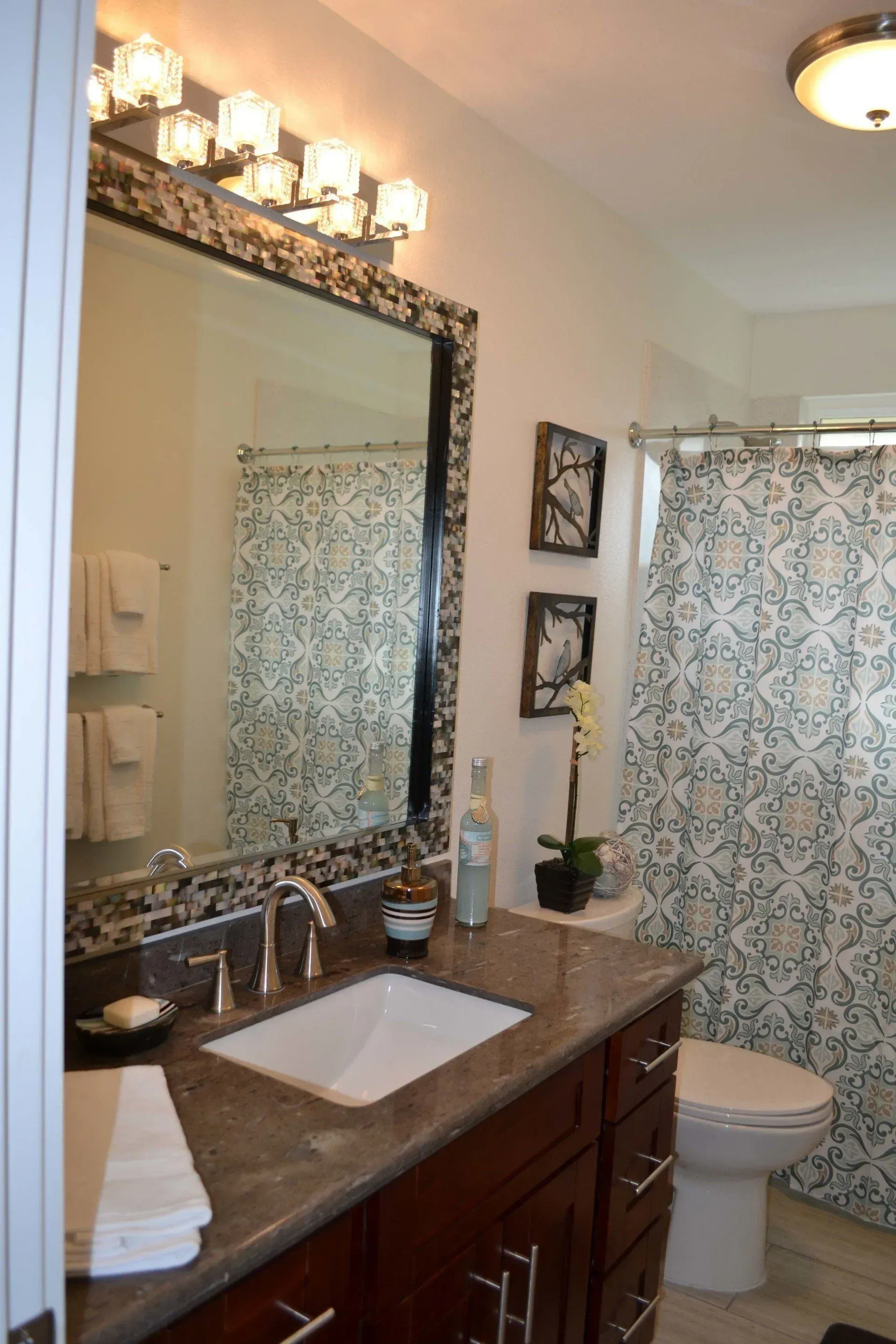 Bathroom with a large mirror, vanity, and shower curtain.