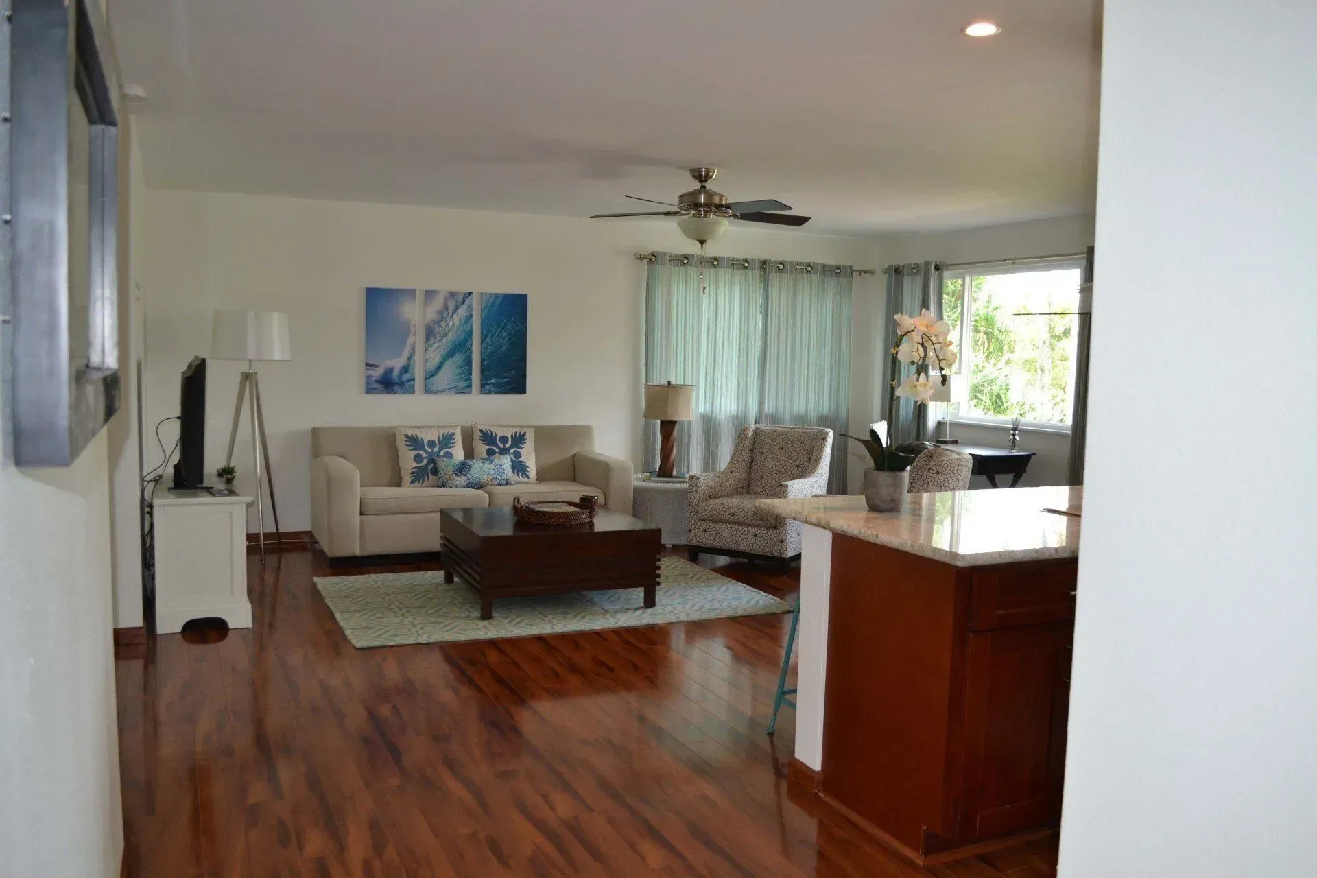 Living room with hardwood floors, sofa, coffee table, and blue wall art.