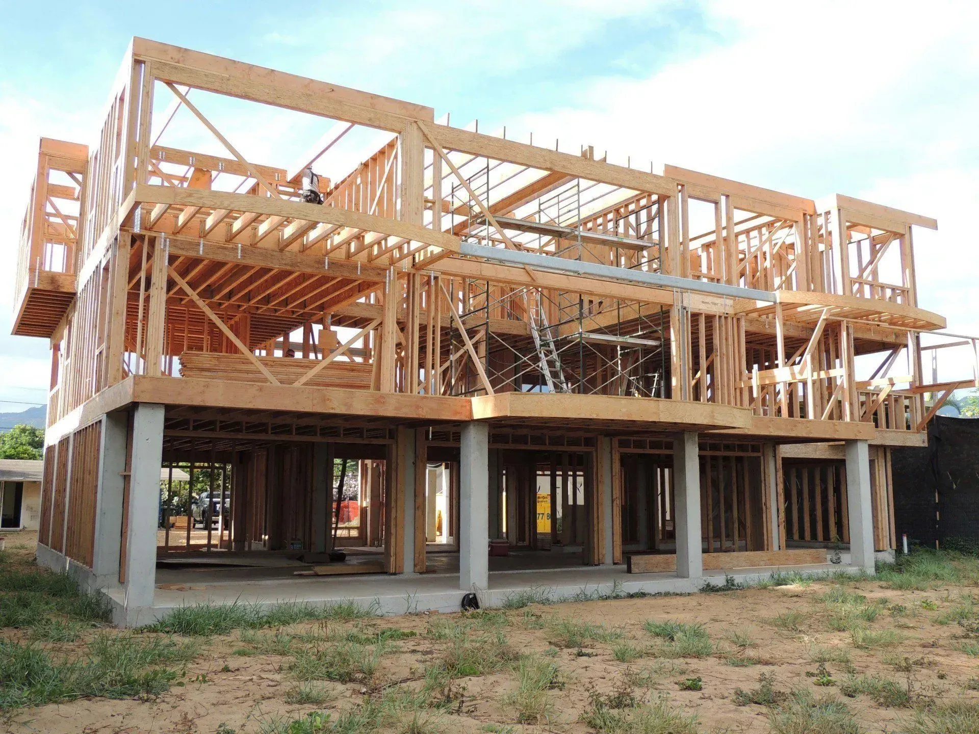 Wooden house frame under construction outdoors.