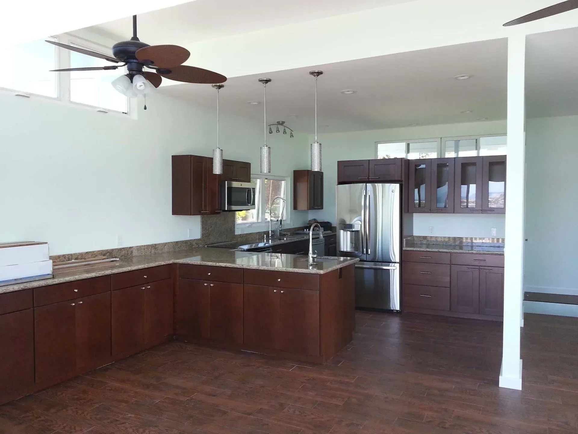 Spacious kitchen with dark brown cabinets, granite countertops, and stainless steel appliances.