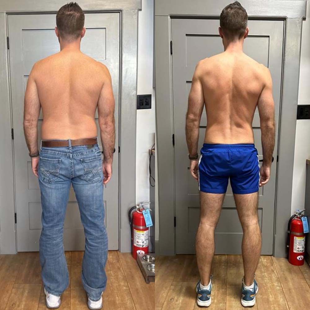 A man without a shirt is standing in front of a door