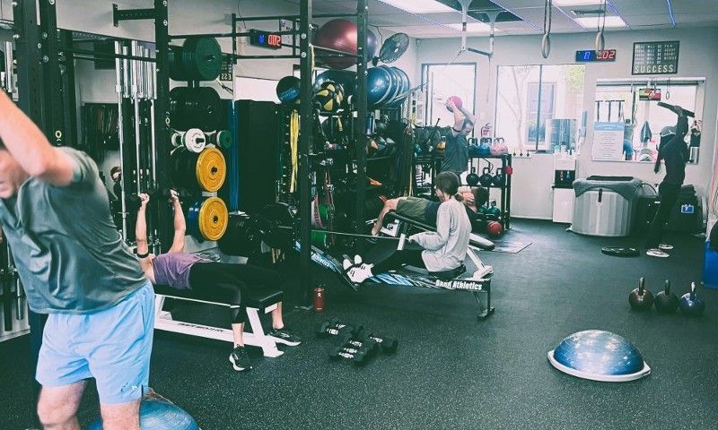 A man is doing stretching exercises in a gym.