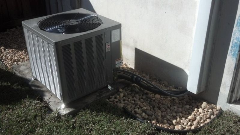 An air conditioner is sitting on the side of a building.