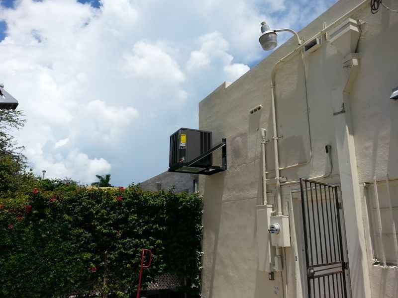 A white building with a black air conditioner on the side