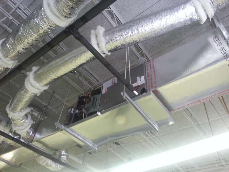 A ceiling with a lot of pipes hanging from it.