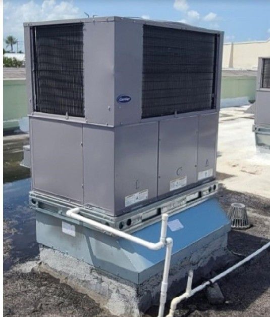 A large air conditioner is sitting on top of a roof.