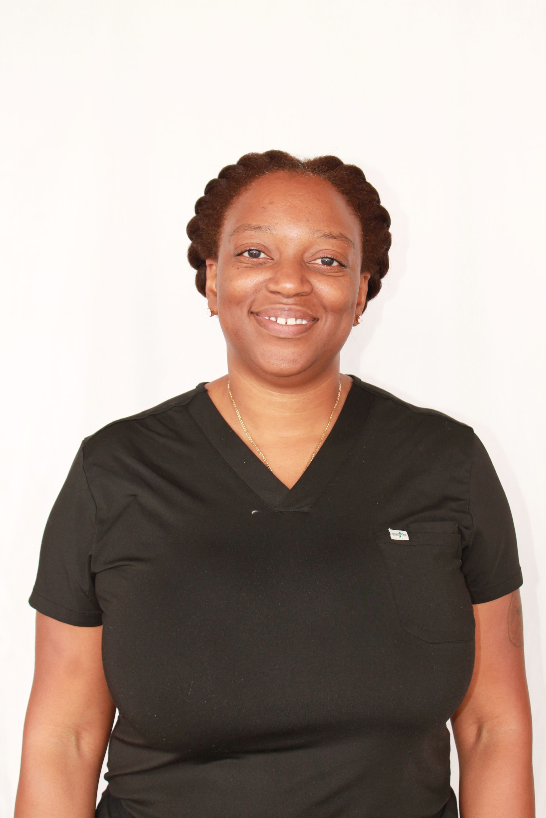 Naomi Pritchett with dark skin smiles wearing a black hooded sweatshirt.