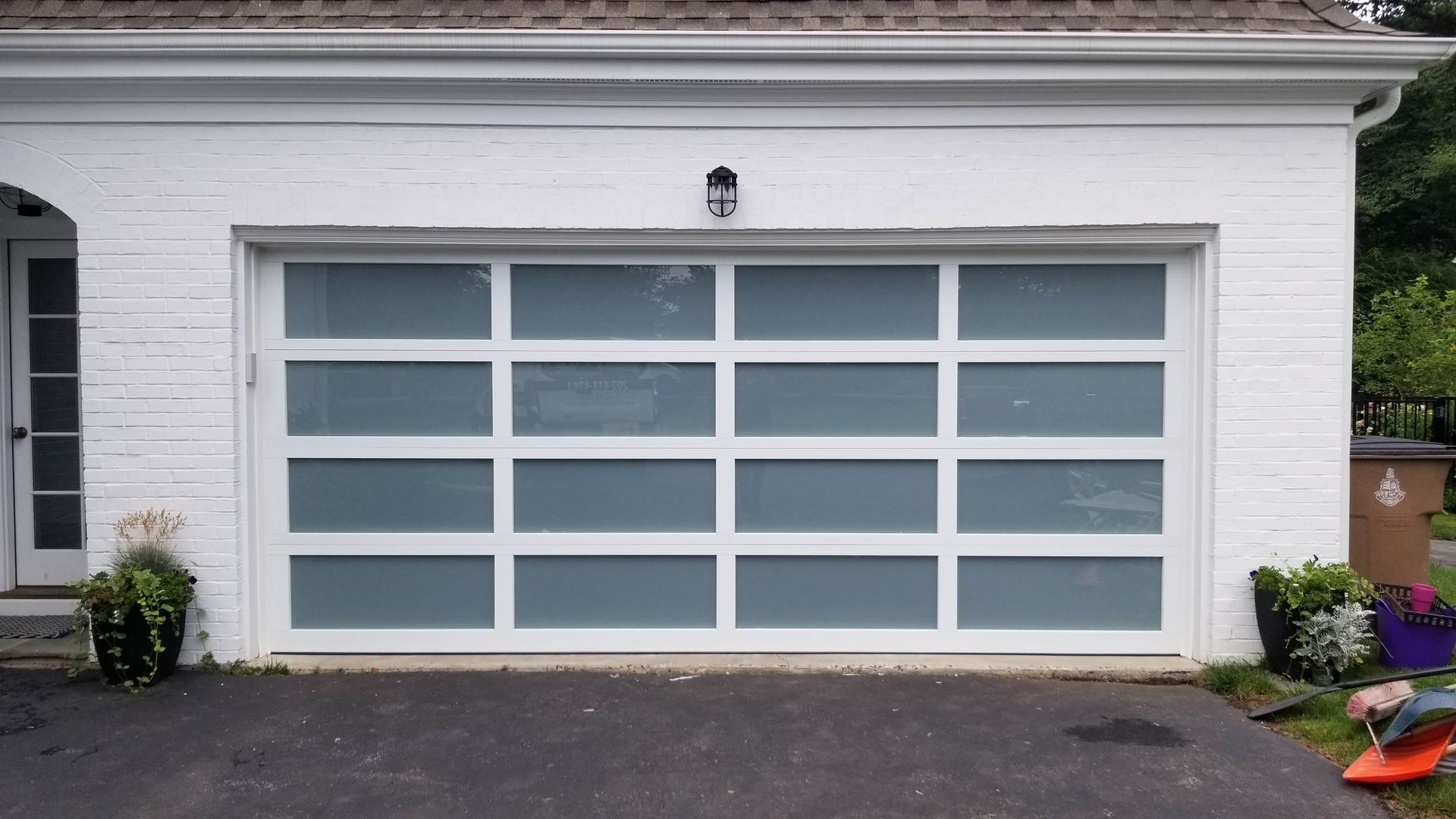 White garage door with frosted window panels on a house exterior