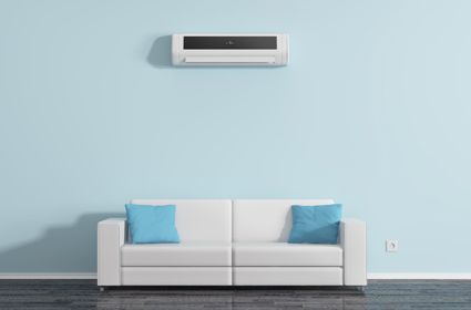 A living room with a white couch and a blue wall.