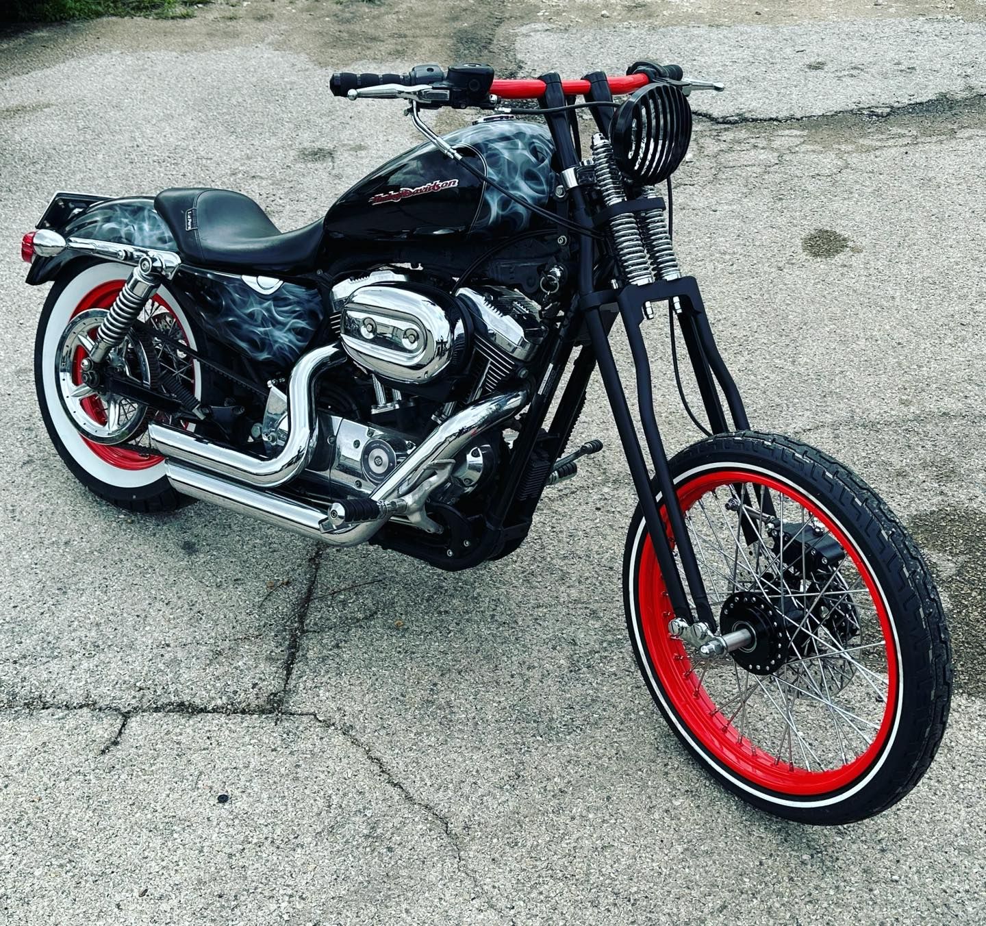 Custom black Harley Davidson motorcycle with red accents and white wall tires.