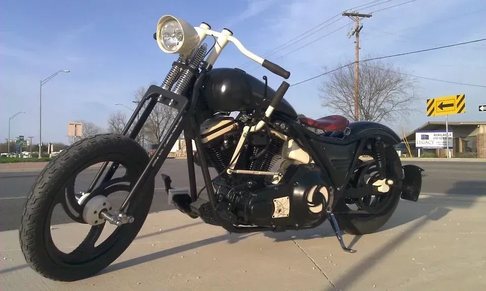 Black custom motorcycle parked on a sunny street.