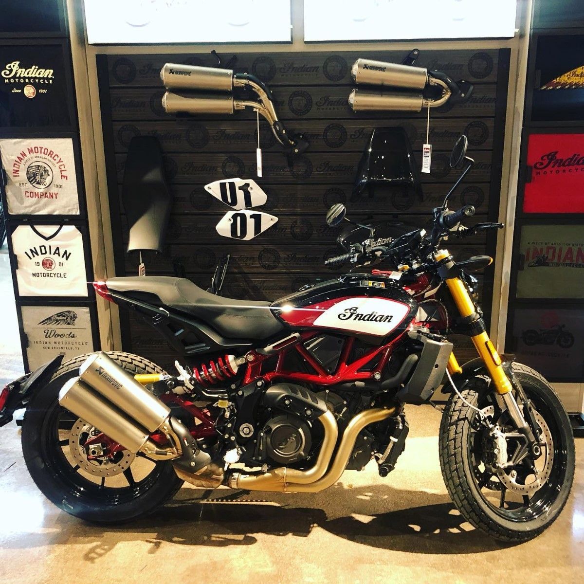 Indian FTR motorcycle in a showroom with red and black accents, pipes, and accessories on display.