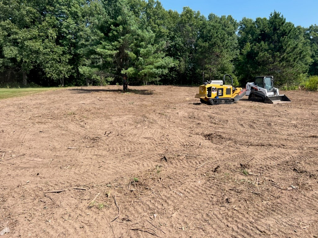 A bulldozer is sitting in the middle of a dirt field.