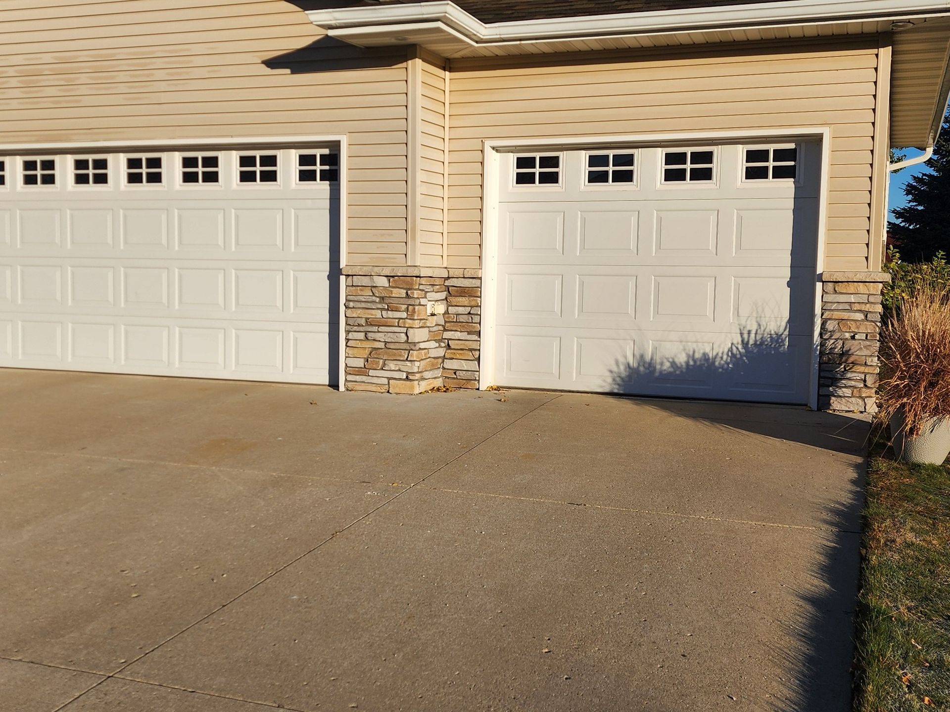 two white garage doors on the side of a house