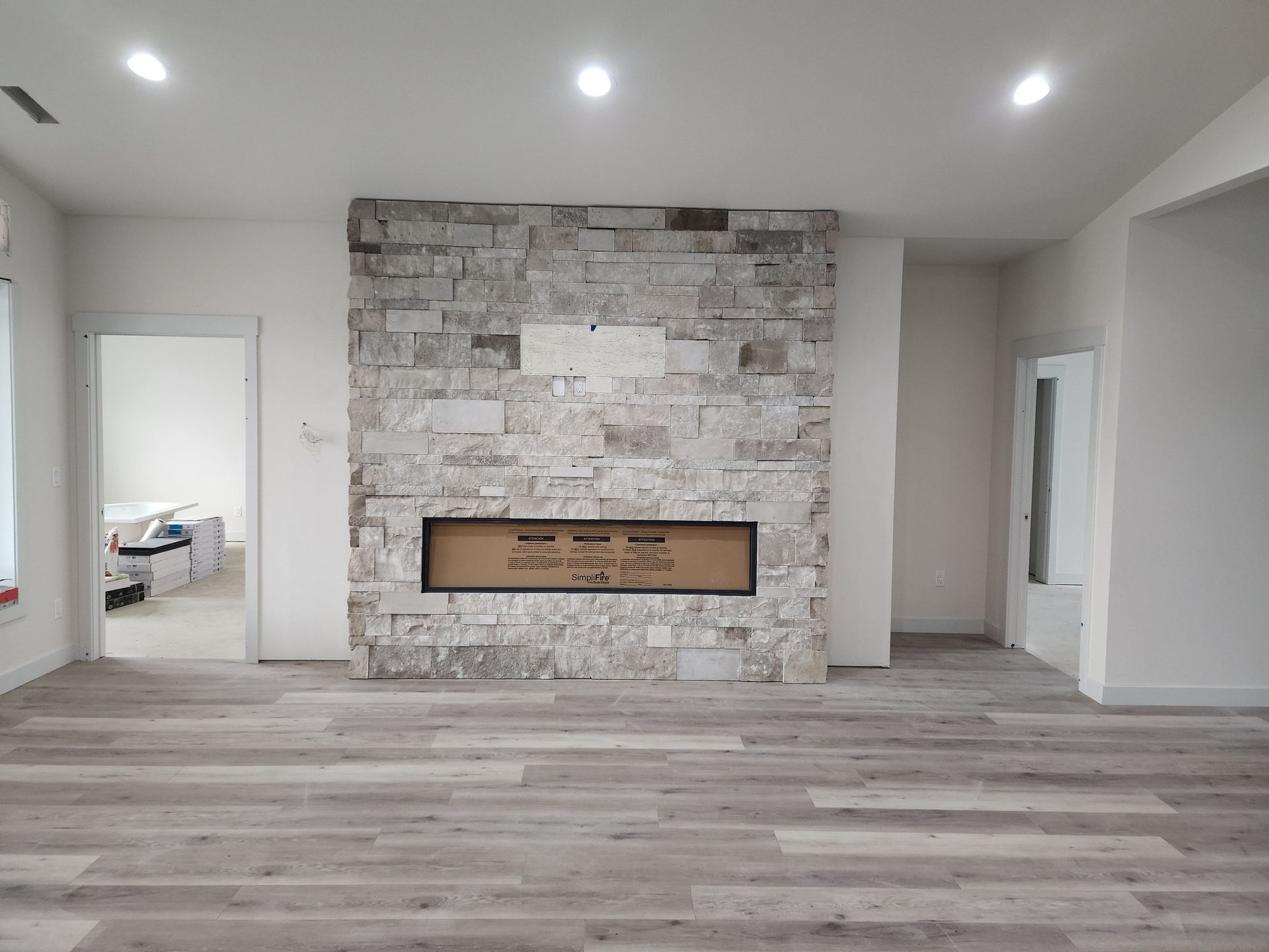 a living room with a fireplace and a stone wall